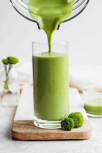 fresh smoothie or green drink being poured from a blender